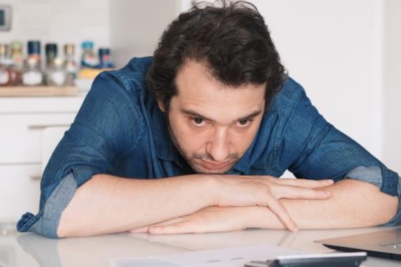 desperate-man-trying-to-find-solution-for-taxes-and-bills-picture-id871291964_1.jpg