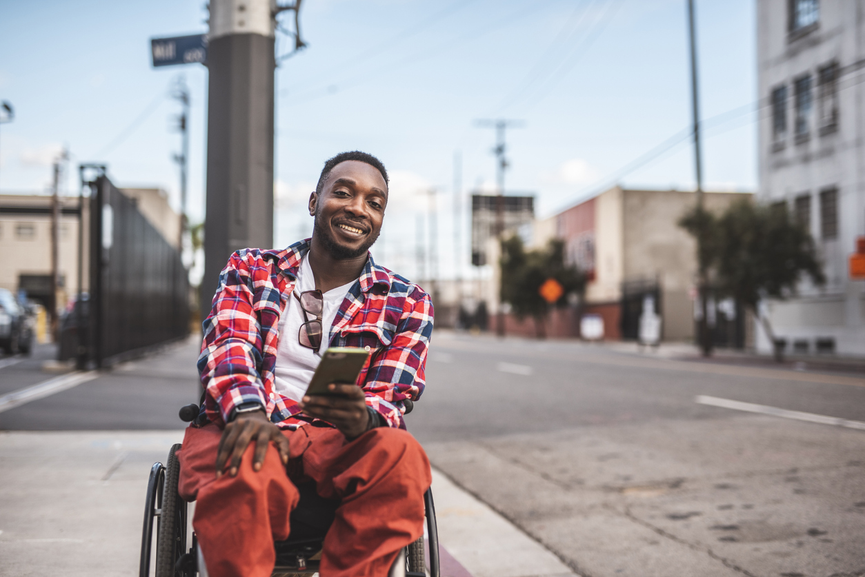 Man with disability smiling while using mobile